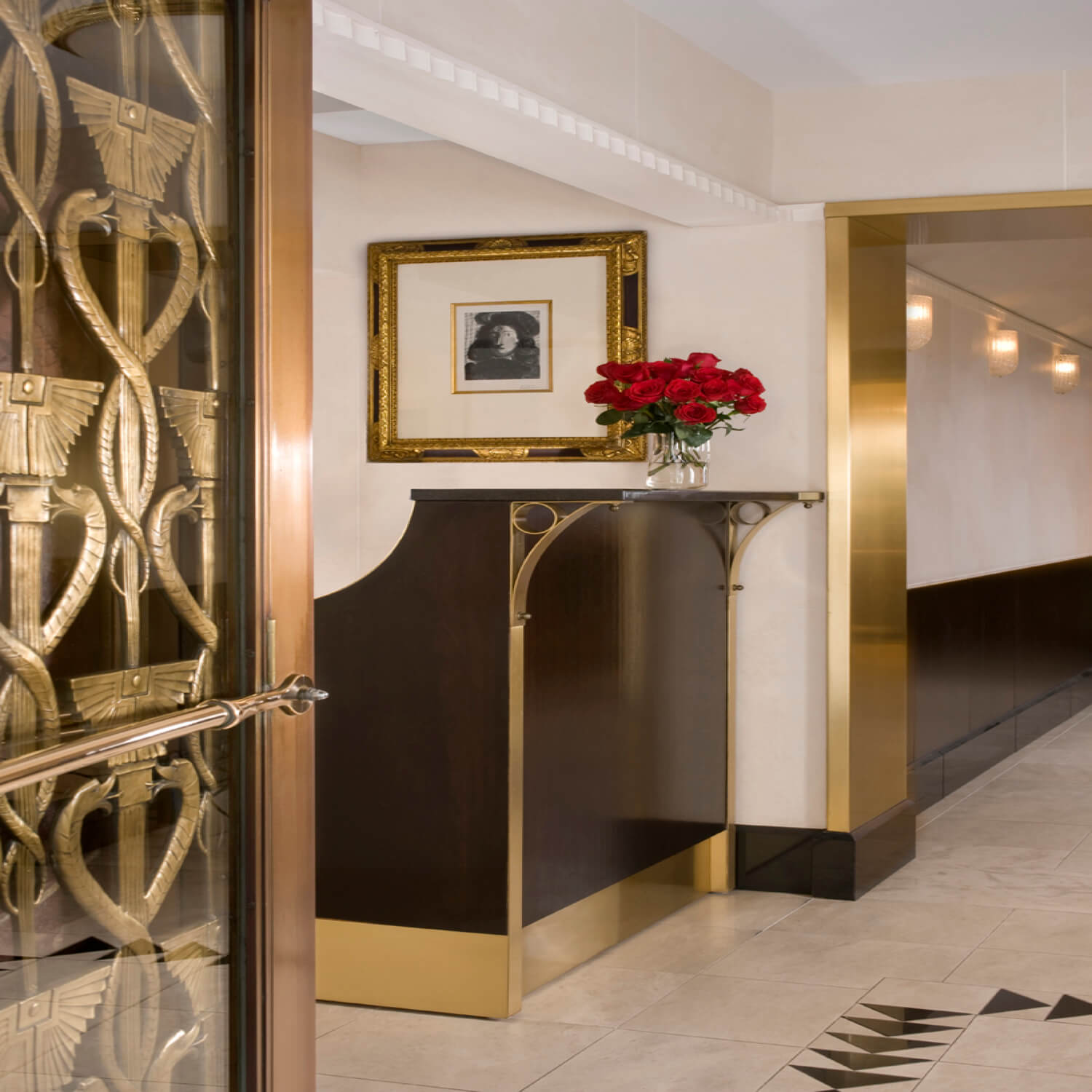 A hallway with a table and a vase of flowers.