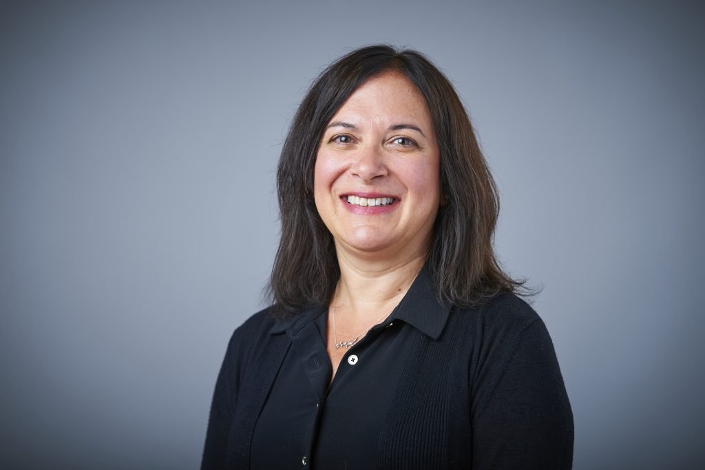 A woman in black shirt smiling for the camera.